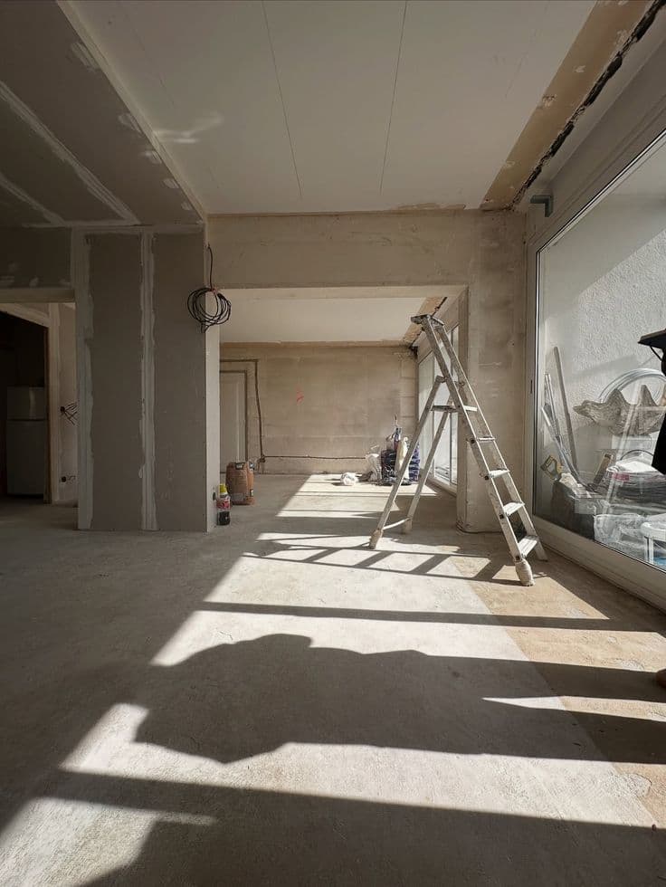 Espacio interior en remodelación con plafón y escalera de trabajo