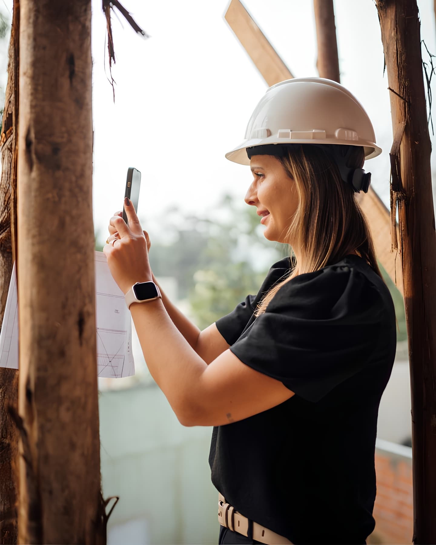 Supervisora de construcción documentando el avance de una obra desde su teléfono